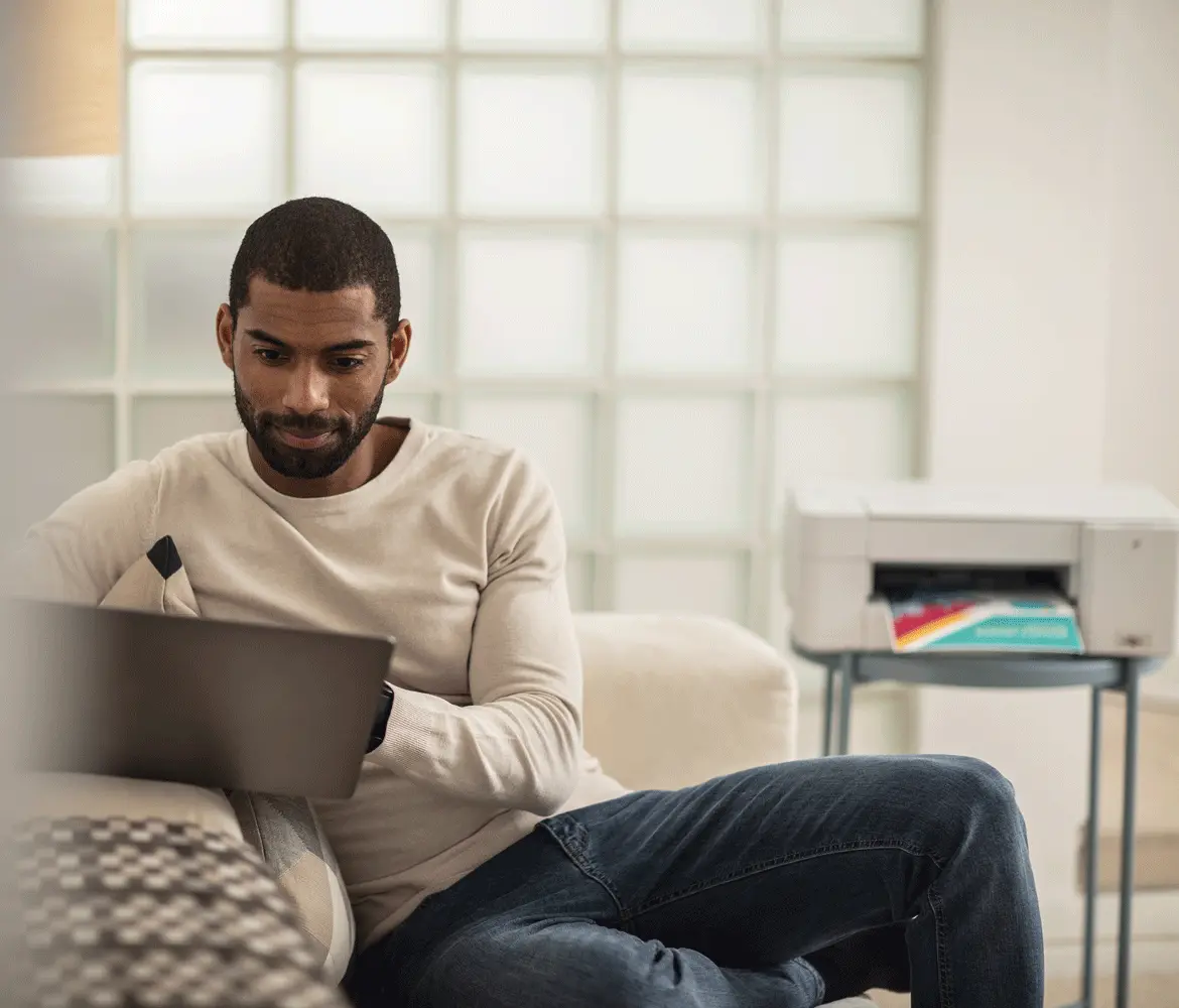 Person using a laptop near a printer